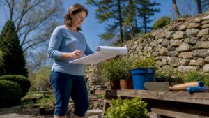 Homeowner reviewing landscape design plans outdoors