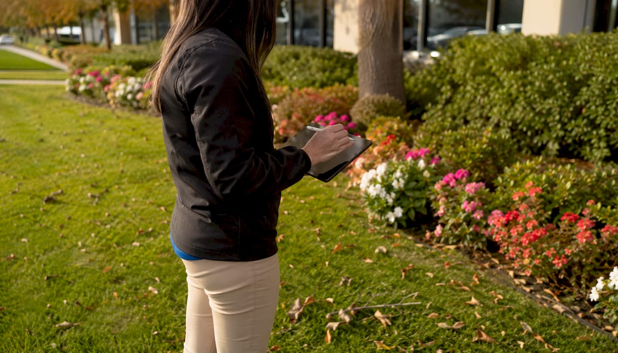 Inspector recording landscape observations outdoors