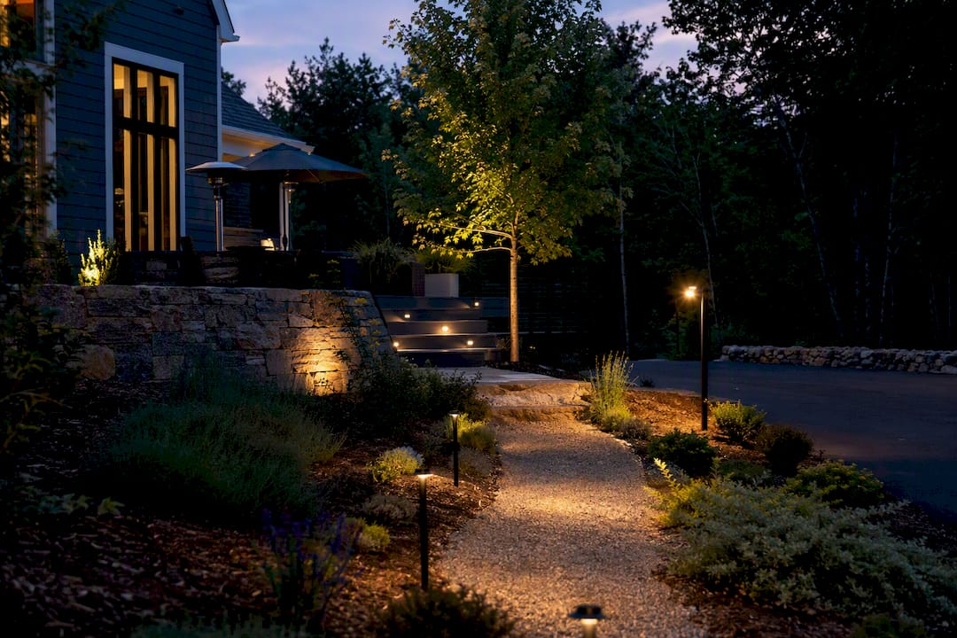 Different landscape light types in a yard at twilight