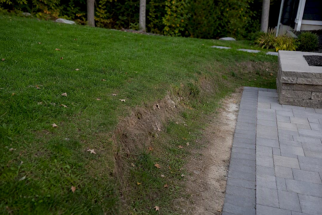 Eroded residential slope showing soil settling
