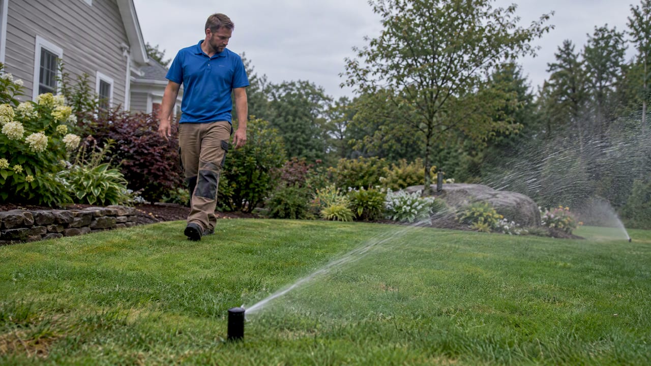 Installer checking active lawn sprinkler coverage
