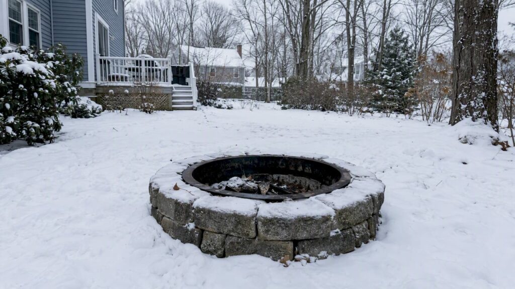 Fire pit surrounded by snow in a New Hampshire yard