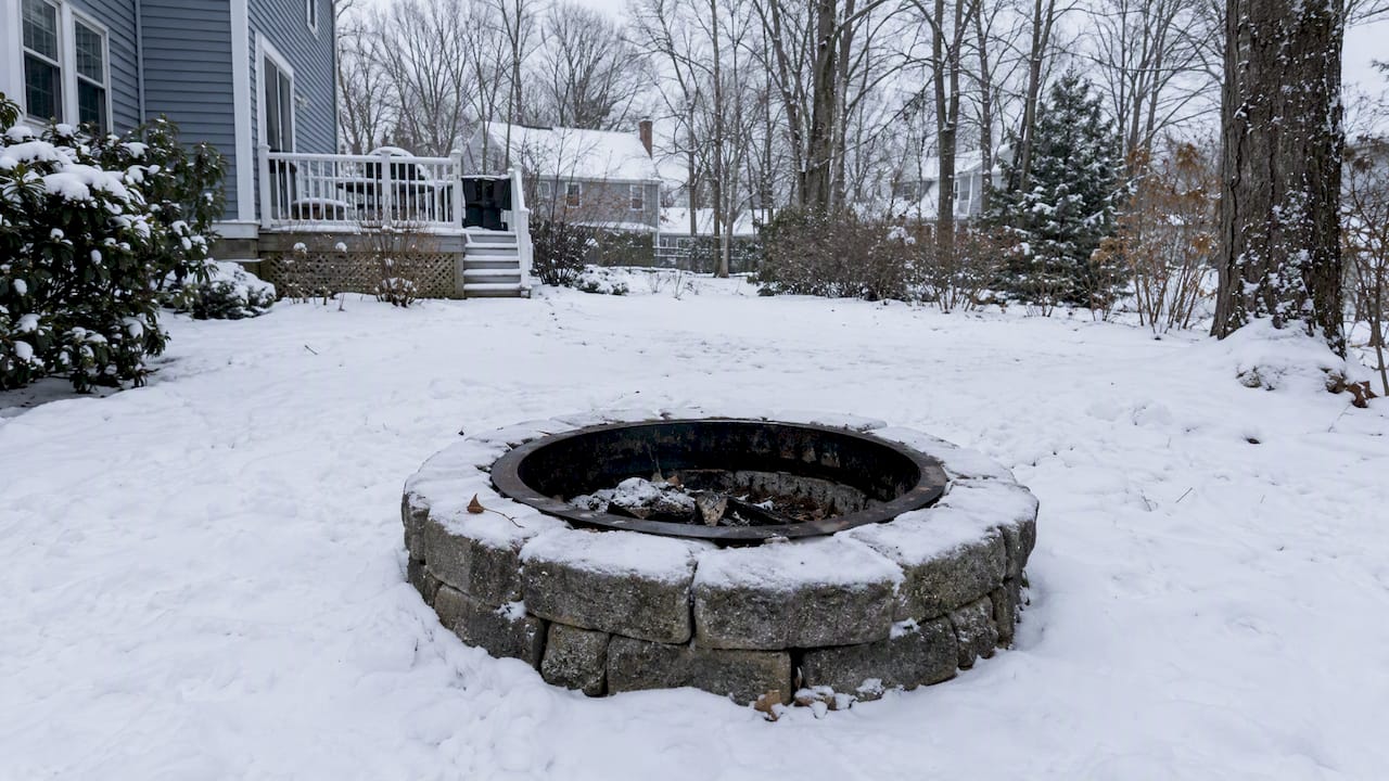 Fire pit surrounded by snow in a New Hampshire yard